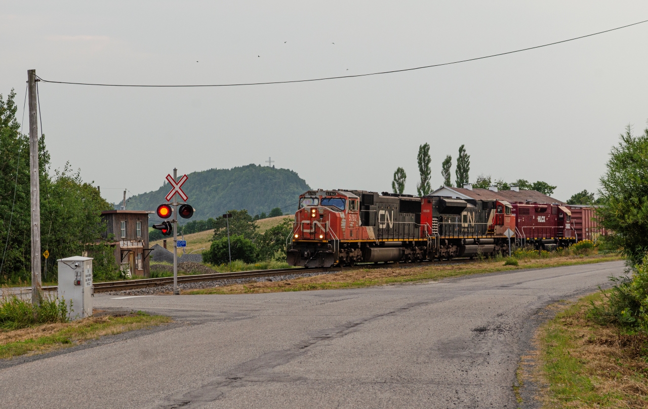 The daily eastbound freight train comes out of the curve with a well-worn SD75I on point under think wildfire smoke. 40 Years ago, this shot would have been impossible with the train being hidden behind what was the town's station. Hard to believe they could fit it in such a tight space!