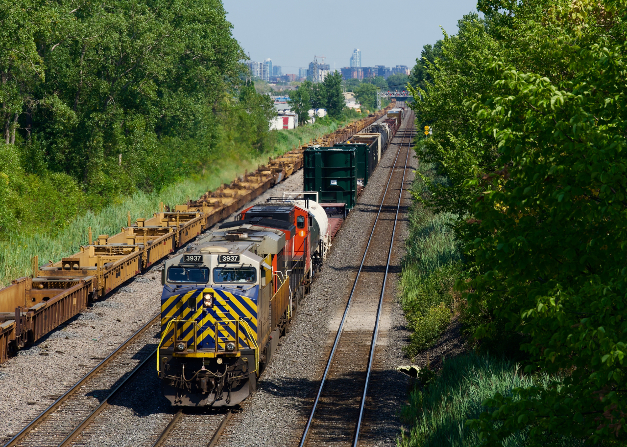 CN 527 has two dimensional loads up front as it crawls towards Taschereau Yard, probably doing all of 5 mph. Power is CN 3937 & CN 3388.