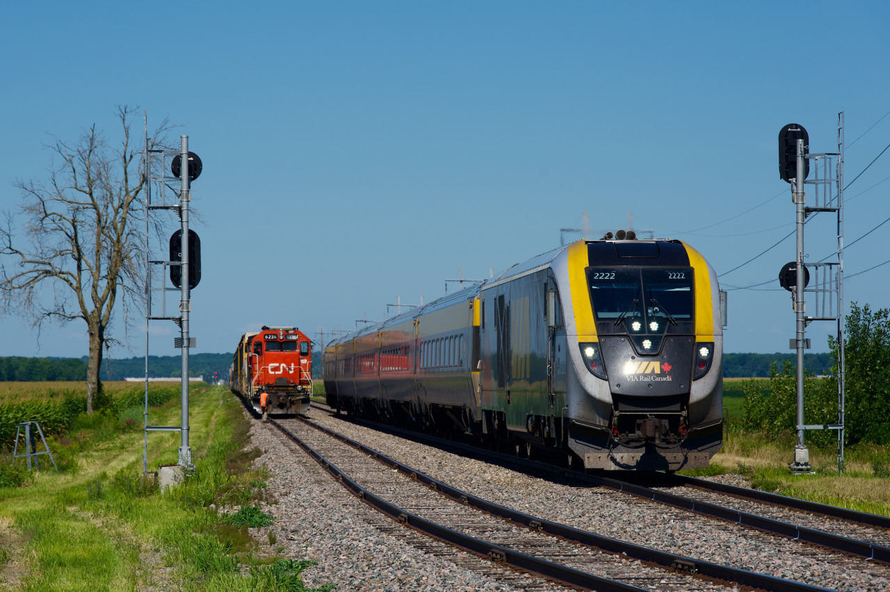 CN 589 is tucked away in the De Beaujeu siding as VIA 24 overtakes it just before it crosses the CPKC Winchester Sub at grade. A few minutes later, CN 589 will get its signal to follow VIA 24 towards Coteau.