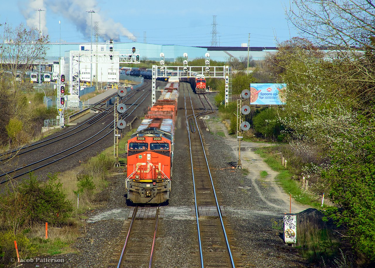 CN M305 proceeds through the plant at Whitby, passing E271 in the south service track.