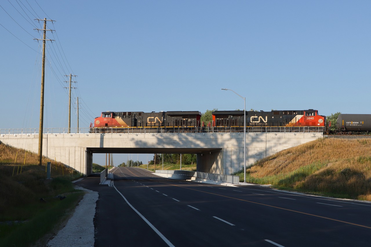 An eastbound works up the grade toward Ash passing over the recently completed overpass for Lower Baseline Road replacing the road crossing at grade. This grade separation is another key infrastructure component for the CN Milton Logistics Hub. The future Controlled Location for the west entrance to the yard will be close to this location. Nice work CN.