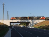 An eastbound works up the grade toward Ash passing over the recently completed overpass for Lower Baseline Road replacing the road crossing at grade. This grade separation is another key infrastructure component for the CN Milton Logistics Hub. The future Controlled Location for the west entrance to the yard will be close to this location. Nice work CN.
