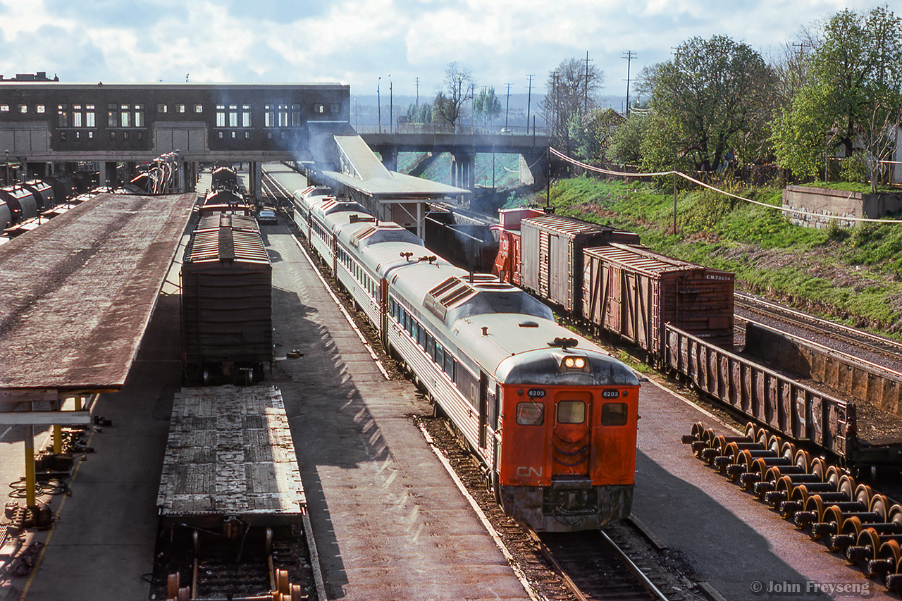 Having arrived from Toronto as train 641, a consist of four Budd cars departs Hamilton James Street station as train 642 for Niagara Falls.  Note some of the platforms are now used by the car department for light repairs.

scan and editing by Jacob Patterson.
