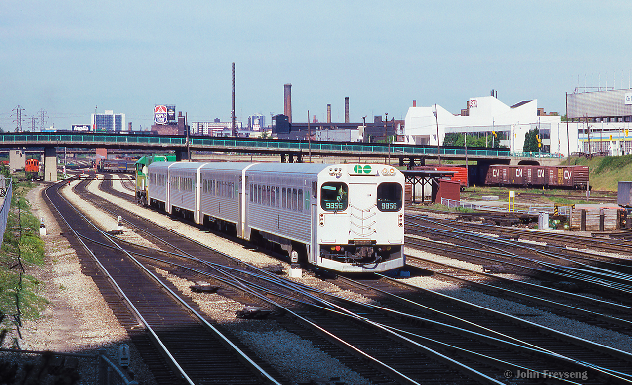 An eastbound GO train from Oakville approaches Union Station, just past Spadina Avenue.  GMD GP40TC 503 pushes on the rear.  In the distance, CNR 6060 has just departed for Niagara Falls, passing under Bathurst Street.

Scan and editing by Jacob Patterson.