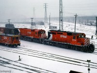 A westbound CP Rail movement makes its way through the activities underway around the Toronto Terminal Railways trackage at Bathurst Street.  A CN transfer van sits at left, while switch tenders clean switches in the background for the four MLW S13 coach yard switchers.

<br><br><i>Scan and editing by Jacob Patterson.</i>