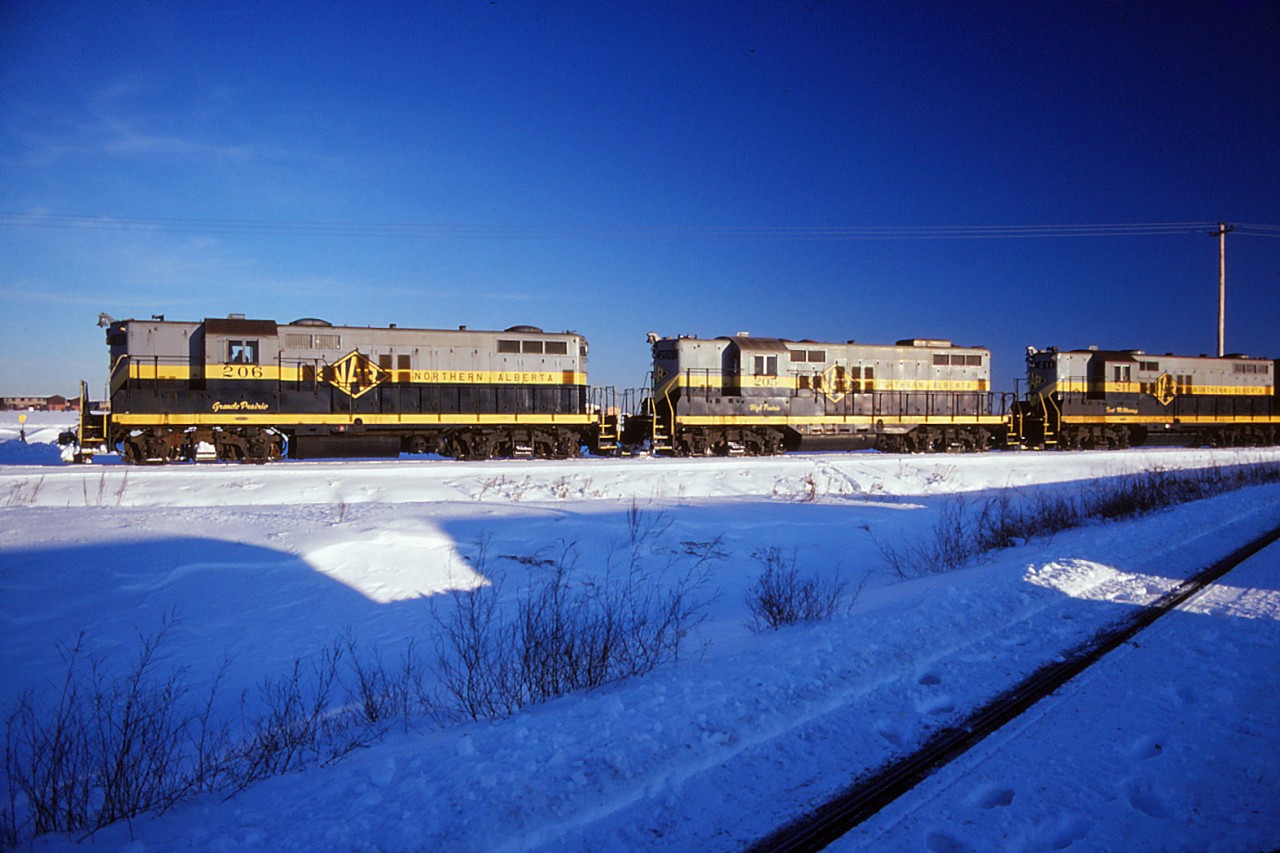 When this photo was taken, the sun was setting on the Northern Alberta Railways--both literally and figuratively. I don't have any background on the photo and can't nail down the date or specific train ID. But I do know that the NAR became the CN Peace River Division on 1 January 1981 (it previously had been jointly owned by CN and CP). The NAR's 10 GP9s entered service in 1958 and would be renumbered to CN 4602-4611 after the acquisition. For the record, the units in the photo are 206, 205, and 211 (the latter having been rebuilt from unit 202 after a head-on collision at Carbondale in November 1959).