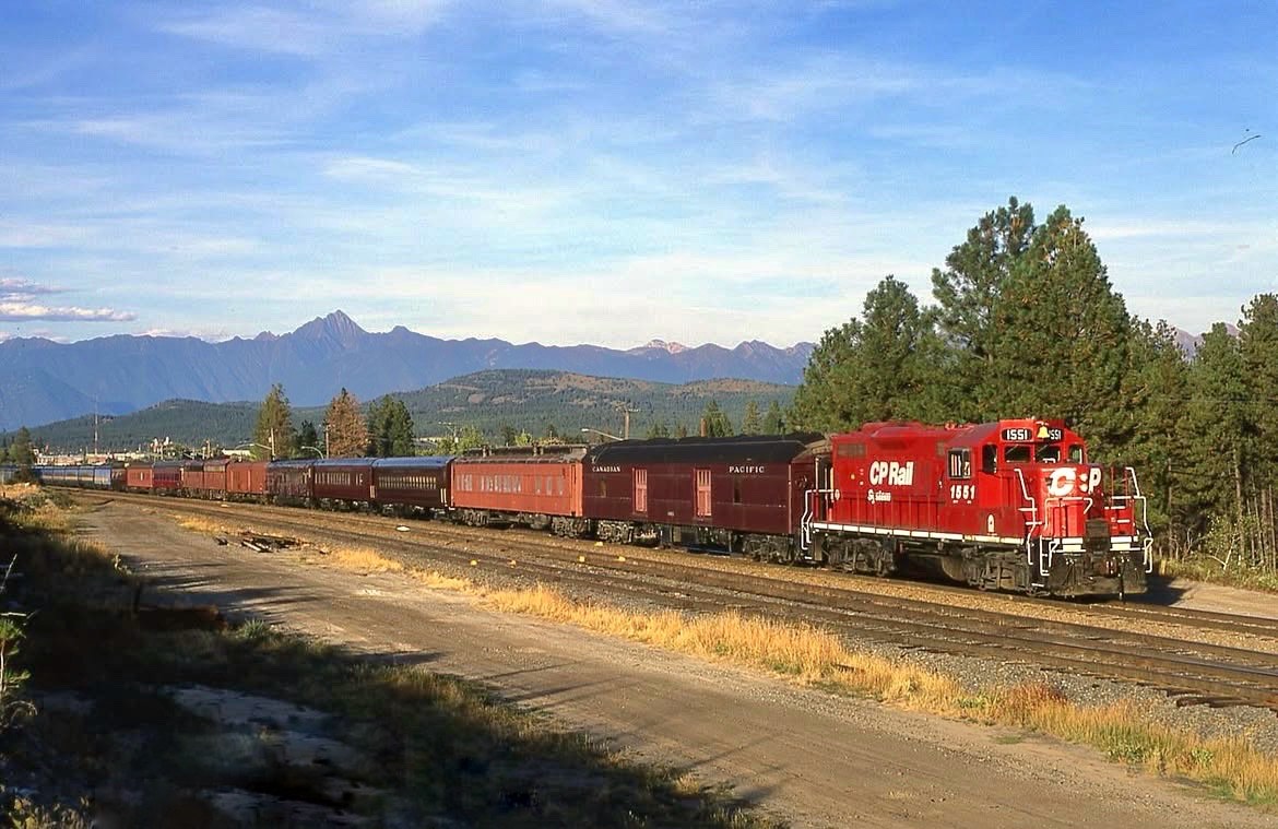 CP 1551 switching several of the 28-passenger car collection belonging to the Canadian Musem of Rail Travel (now Cranbrook History Centre), presumably to their current location.  At the rear of the train are seven privately-owned pieces of equipment, including four Dayniter coaches.  

CP GP9 1551 was built by Electro-Motive Division in 1983 as CP 8513 and retired in 2008.  Note the RCMP Musical Ride logo and the yellow bell.