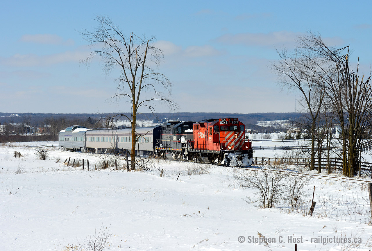 The possibilities photographically speaking on the Orangeville Brampton Railway were nearly endless. I spent a fair amount of time (once or twice a year) coming out for photos, but I still wish I went more. This was a unique set of circumstances and it only happened once. CCGX 4009 was basically dead and CP sent 8249, as the agreement allowed  Cando to borrow a unit if one of theirs died. Knowing it would be on the train, I showed up prior to departure to watch the crew try hard to de-ice equipment to switch out their 2 car train (leaving the dome and 4009 behind) but everything was frozen - so they took everything with them instead. The dome car was not in revenue service at the time. With the amazing blue sky weather and the scenery, this was an opportunity I could not pass up. I would come back a week later, because 8249 died apparently on this day, and CP sent a brand new ECO with only 1079 miles on the odometer, another passenger train was to run the next weekend, the last of the season - and the weather was of course going to be amazing. Off to Orangeville I go...
Pictured is Engr. Wayne Thompson at the throttle taking care of business on the 2'nd to last Snow train of the  season. This impressive little passenger train is on the approach to Snelgrove station where they will turn to head back north after running around to the dome car side.