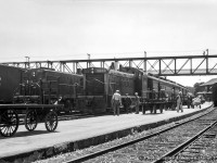 Pausing at Palmerston, brand new GMD SW1200RS 1317, built in August 1958, is in charge of Hamilton - Owen Sound train 173.  Diesel locomotives have only appeared in Palmerston during the previous two years, and primarily MLW RSC13s, such as 1722 at left on the point of mixed train M329 for Southampton.  

<br><br>During this short stop, crew members are busy handling mail and express shipments into the RPO and baggage cars, while an outbound crew, potentially that of M329 at left, take in the sight of the new locomotive.  At right, the coach for mixed train M331 to Kincardine is spotted on the stub track.  After 173's 1120h departure, both M331 and M329 will depart at 1135h. The mixed trains will arrive back at Palmerston at 1525h and 1530h respectively, giving passengers half an hour until the 1600h arrival of 174 for Hamilton.

<br><br><i>Original Photographer Unknown, Jacob Patterson Collection Negative.</i>