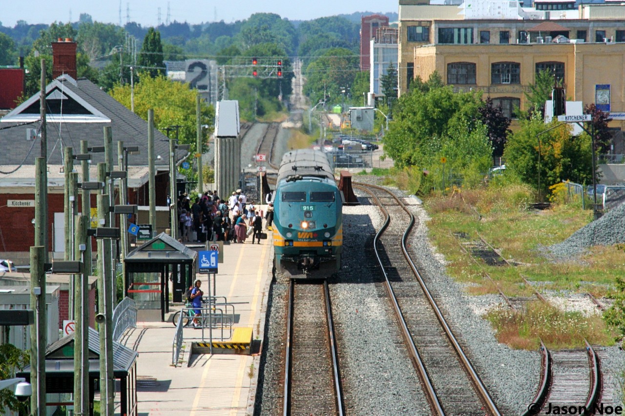 VIA Rail train 84 with P42DC 915 makes its station stop at Kitchener, Ontario on the Guelph Subdivision as a full platform of passengers await. Since this spring, the new VIA Siemens Charger/Venture sets have been predominantly assigned to 84 and 87, replacing the aging P42DC’s and the classic Budd coaches.