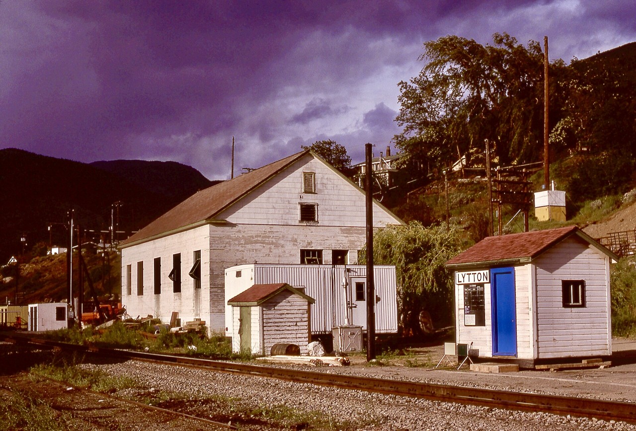 Lytton, on CN’s Ashcroft subdivision between Kamloops Jct. (0.0) and Boston Bar (125.5) and at the confluence of the Fraser and Thompson Rivers, originally had a Canadian Northern Pacific depot on the site of the modest VIA flagstop shelter (complete with the green-and-white flagstop signal) shown here on Friday 1980-05-23 looking eastward.  The substantial building nearby was a repeater station for telegraph and telephone signal circuits.
