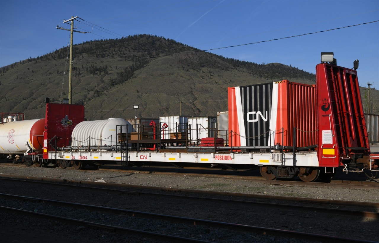 CN Poseidon  
CN 100004 bulkhead flat is part of CN's Poseidon Fire Fighting consist and is resting at their Kamloops, BC yard Mile 139.4 Clearwater Sub. on a beautiful April 30, 2025 evening. 
I captured this and several other cars of the special service train during a scheduled stop of VIA 001 The Canadian. 
There is always so much to see when traveling across Canada by train. :-)
