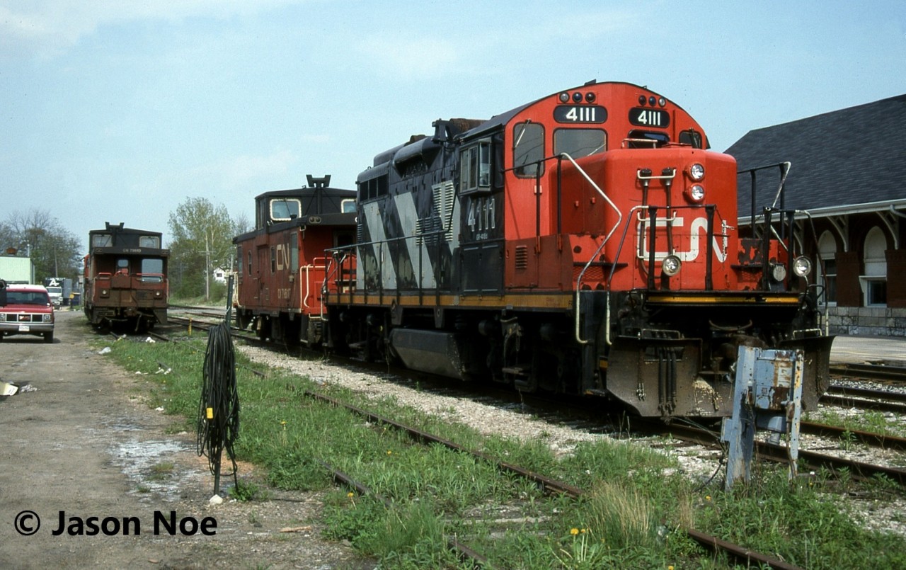 During a Saturday evening, CN GP9RM 4111 with caboose 79817, along with GP9RM 4109 and caboose 79513 await their next assignments in Kitchener, Ontario. Unlike today, during the mid-90’s the Kitchener-based CN locals rarely worked on the weekends, so power was easily shootable across from the VIA Rail station.