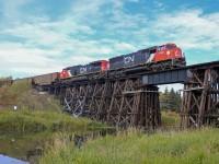 Behind two AC conversions (8332 and 3401), a 98-car sulphur train makes its way slowly through St. Albert and over the Sturgeon River. Originating in Whitecourt, S72151 will pull in to Walker Yard where the power will be cut off and the cars added to a westbound for Thornton Yard. This portion of the Sangudo sub was once part of the Canadian Northern main line to Port Mann, British Columbia (now Thornton Yard). It was relegated to a branch line when the Canadian Northern and Grand Trunk Pacific lines through Yellowhead Pass were rationalized during World War I.