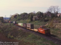 Bringing up the rear of the Toronto-area transfer heading down the Don Branch from Leaside (with CP RSD17 8921 in the lead), caboose 438813 in the short-lived late 60's "Action Script" paint trails southbound at Bayview Avenue, with the Prince Edward Viaduct at Bloor Street showing in the distance in this morning shot. Piggyback and container traffic brings up the tail end, with green CP Ships containers and a Norfolk & Western trailer visible. The head end is probably crossing over the <a href=http://www.railpictures.ca/?attachment_id=54970><b>1/4 mile bridge</b></a> by the Don Valley Brickworks.
<br><br>
<i>Bob Schmidt photo, Dan Dell'Unto collection slide.</i>