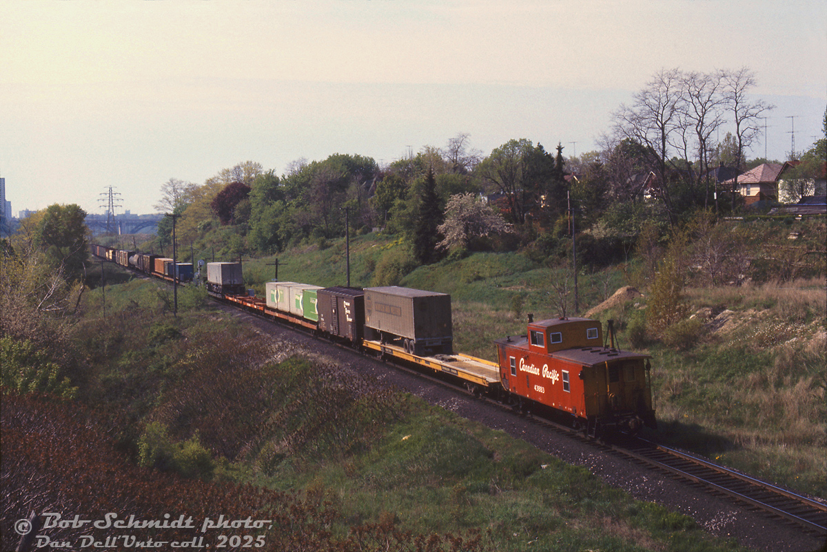 Bringing up the rear of the Toronto-area transfer heading down the Don Branch from Leaside (with CP RSD17 8921 in the lead), caboose 438813 in the short-lived late 60's "Action Script" paint trails southbound at Bayview Avenue, with the Prince Edward Viaduct at Bloor Street showing in the distance in this morning shot. Piggyback and container traffic brings up the tail end, with green CP Ships containers and a Norfolk & Western trailer visible. The head end is probably crossing over the 1/4 mile bridge by the Don Valley Brickworks.

Bob Schmidt photo, Dan Dell'Unto collection slide.