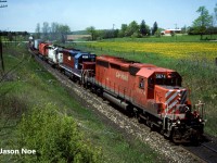 CP SD40-2 5674 is pictured leading an eastbound train under the wooden bridge near the Highway #2 crossing, just west of Woodstock, Ontario on the Galt Subdivision. The crew had just met train 511 with 5909 west at Zorra and was continuing east with work ahead at Woodstock and Guelph Jct. The consist included; HATX GP40 521, HLCX SD40 5007 and M-636 4743. The big MLW was eventually retired a few months later on August 28 and was sold to the Delaware-Lackawanna Railroad in 1997. 
