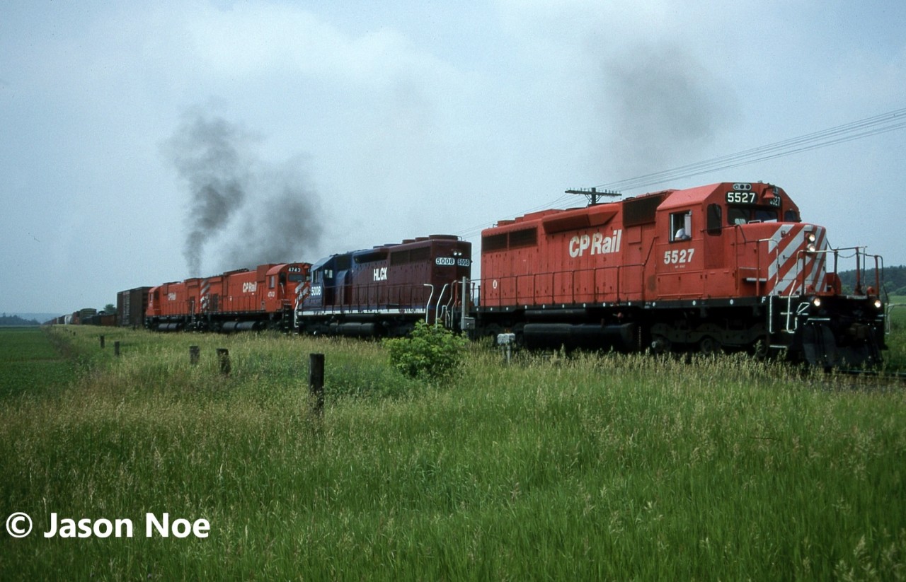After a meet with SOO 6621 west (train 503) at Wolverton, Andy and I waited at the crossing for the conductor of 5527 east to turn the switch after they received their clearance to depart the siding following the meet. Within a couple minutes, M-636’s 4742 and 4743 put on a smoky show, exiting the siding, trailing SD40 5527 and HLCX SD40 5008. Their thick black exhaust lingered in the humid air, as the eastbound increased speed and clattered out on the main. A mainline both M-636’s called home for decades.  Fittingly just like that it came to be that was the last time I ever saw a CP big alco in active service as the pair were shut down and retired later that summer.