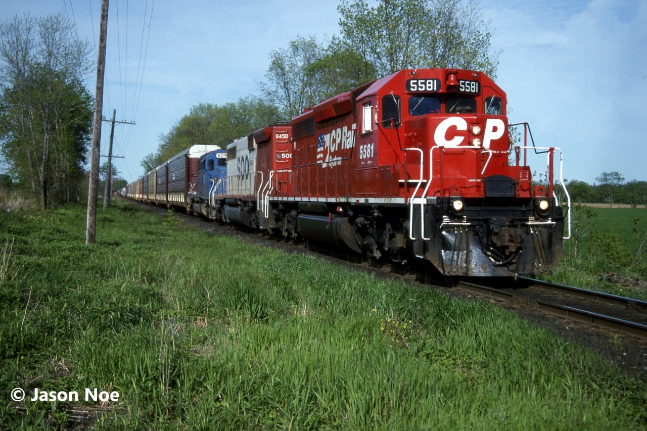 CP train 505 with SD40-2 5581, SOO Line SD40B 6450 and CR Leasing SD40 609 are approaching the east siding switch at Wolverton, which is situated just west of Ayr, Ontario on the Galt Subdivision. Here they would meet train 510, which had already taken the siding at Wolverton. This one of a kind SOO Line unit is ex-BN SD40B 7600 and nee-BN SD40 6302. While CRL SD40 609 is ex-Conrail 6262 and nee-PC 6262.