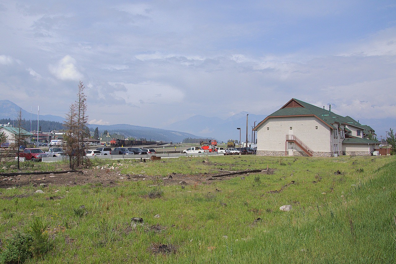 The view is north - east, not much in the yard, as the CN move out of Jasper (mile 235 Edson Sub) is underway, the full move to Hinton (mile 184 Edson Sub) scheduled for autumn 2025. 


As of June, CN crew changes continue, trains stop briefly, from left, that's CN 2856 west with coal loads awaiting crewing, CN 2977 awaiting assignment, ex Citirail CN 3986 in gray. 


At right is the CN Bunkhouse / Offices, note the green trees at extreme right.


The foreground bare spots were trees that burned. Due to safety issues - given the burnt tree trunks remain standing -  forestry crews have removed the burned trunks along road and rail rights of way throughout the Park however the sides of nearby mountains are forests of standing blackened trunks.


The station is visible above / beside CN 2856. The 'good' part of Jasper is evident, to the left out of the image the west and south side of Jasper is mainly destroyed.


The green grass at Jasper, June 12, 2025 digital by S.Danko