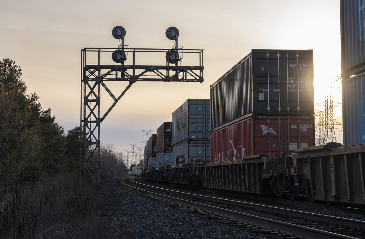 Headed into the late evening sun, CN Z149 rolls westward under 1960's-era searchlights at McCowans on the York Subdivision.