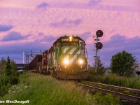 Wow, it's hard to believe this was already over two years ago. I thought I'd post this frame as it's finally been confirmed that BNSF 2098 (now CN 4957) has been repainted into CN colours after being purchased a year or so ago by CN following a lengthy stay on horsepower hours. Here it is while under assignment to Brantford back in June 2023, taking the lead of L581 as they begin heading back home after working some industries on the glass lead in Milton; a task normally completed by L551. 

The sun was just setting over the horizon and due to the cloud cover in the area it illuminated the sky above in a mixture of pink & purple, to this day I'm not sure I can recall such a dramatic scene while trackside and I feel it really gives this shot an extra punch. 

The 2098 as well as a decent bunch of other BNSF geeps were lent to CN by BNSF for the supposed reasoning of repaying horsepower hours back around the springtime of 2023. Normally horsepower hours are repaid between the class 1s with standard road power, but CN being desperate for 4-axles since the retirement of the GMD-1s as well as the GP9s getting older and weaker lead to them doing this unconventional method. It appears that most units BNSF lent were serviceable engines that would otherwise be in storage due to a surplus of 4-axle power within their own network, so eventually CN was able to purchase most of the engines they were currently "borrowing". As of 2025, some are still roaming around with their BNSF identities fully intact, some have been patched out, and others sent to shops for overhauls and repaints, which was unfortunately the case with the 2098. Initially I was hoping for a patch job that would  leave the stripes on the nose intact, but no such luck. 

With that being said, hopefully you enjoy what was probably the best shot I managed of this guy before it's makeover. 