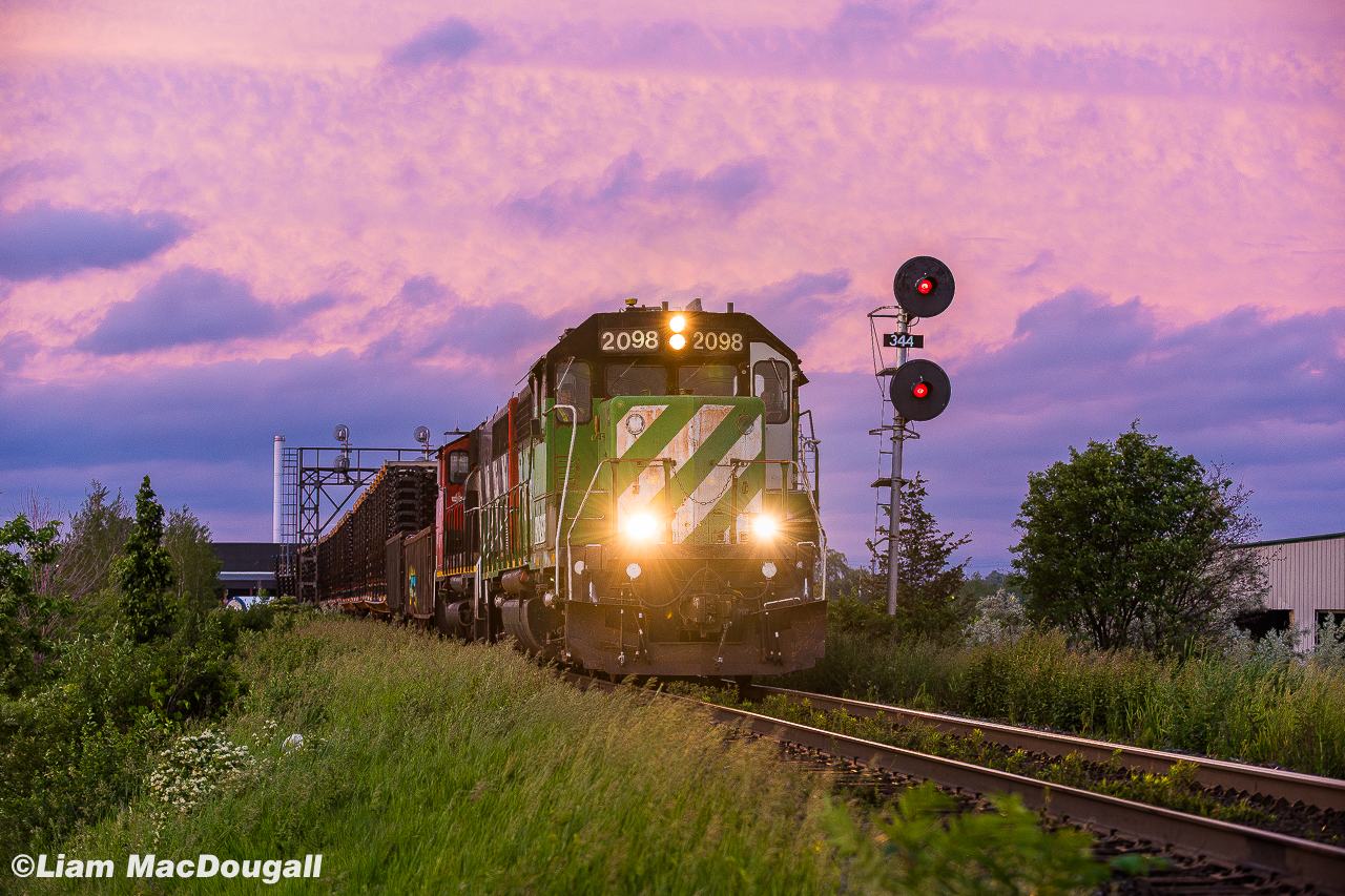 Wow, it's hard to believe this was already over two years ago. I thought I'd post this frame as it's finally been confirmed that BNSF 2098 (now CN 4957) has been repainted into CN colours after being purchased a year or so ago by CN following a lengthy stay on horsepower hours. Here it is while under assignment to Brantford back in June 2023, taking the lead of L581 as they begin heading back home after working some industries on the glass lead in Milton; a task normally completed by L551. 

The sun was just setting over the horizon and due to the cloud cover in the area it illuminated the sky above in a mixture of pink & purple, to this day I'm not sure I can recall such a dramatic scene while trackside and I feel it really gives this shot an extra punch. 

The 2098 as well as a decent bunch of other BNSF geeps were lent to CN by BNSF for the supposed reasoning of repaying horsepower hours back around the springtime of 2023. Normally horsepower hours are repaid between the class 1s with standard road power, but CN being desperate for 4-axles since the retirement of the GMD-1s as well as the GP9s getting older and weaker lead to them doing this unconventional method. It appears that most units BNSF lent were serviceable engines that would otherwise be in storage due to a surplus of 4-axle power within their own network, so eventually CN was able to purchase most of the engines they were currently "borrowing". As of 2025, some are still roaming around with their BNSF identities fully intact, some have been patched out, and others sent to shops for overhauls and repaints, which was unfortunately the case with the 2098. Initially I was hoping for a patch job that would  leave the stripes on the nose intact, but no such luck. 

With that being said, hopefully you enjoy what was probably the best shot I managed of this guy before it's makeover.