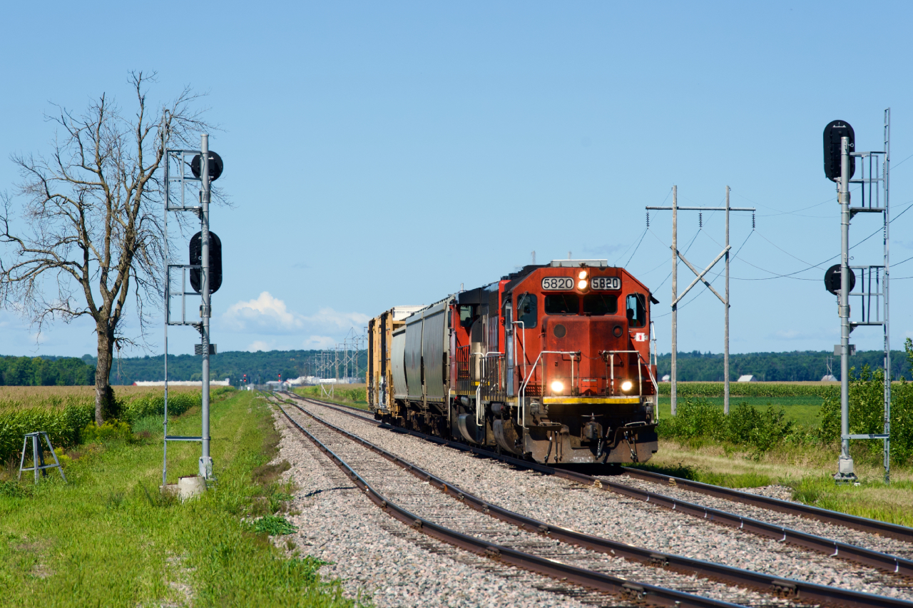 CN 589 with GTW 5820 leading and only five cars is about to hammer the diamond at De Beaujeu. With the three hoppers about to be set off at a client, the train will arrive at Coteau with only the two boxcars.
