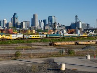 VIA 63 has an F40 and a HEP coach deadheading on the rear as it passes the skyline of downtown Montreal.