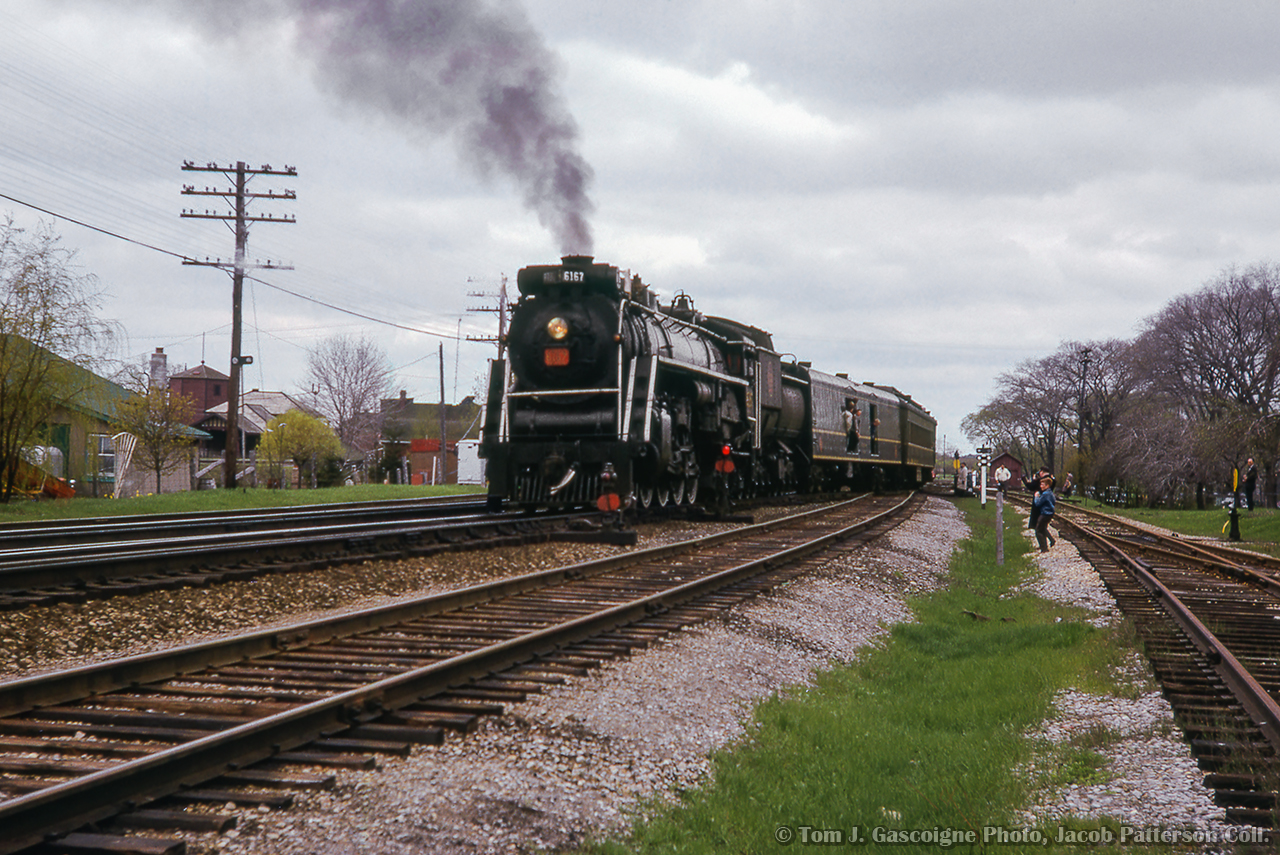Lined into the small yard at Cobourg, CNR 6167 shoves its excursion consist into the clear in preparation for servicing prior to the westbound run for Toronto.  Today's excursion from Toronto included a stop at Oshawa for traction fans to take in the Oshawa Railway operations which were in the last few years of operation. This day marked the last train down King Street, celebrated by a parade as motor 300 hauled a single boxcar through town.  Note the empty CPR water tower at left along the CPR Oshawa Sub.  Shortly, 6167 and baggage car will head around the wye.


Steve Bradley would shoot the special after its westbound departure from Oshawa highballing through Port Union.

Arrival at Cobourg

Tom J. Gascoigne Photo, Jacob Patterson Collection Slide.