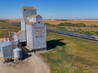 The westbound Canadian, is running right on schedule as they cruise past the elevator at Redord.  While it is no longer served by rail, and flanked by two super elevators, the structure is still used by local farmers for storing grain. 