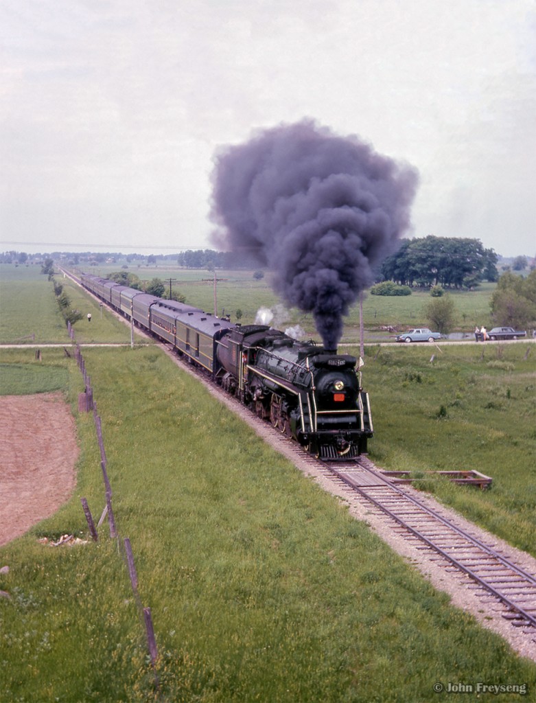 Black coal smoke blasts high above the farmland near Milverton as an Upper Canada Railway Society excursion behind CNR U-2-e 6167 is seen along the Newton Sub, about to duck under CPR's Goderich Sub.  The train, carrying over 500 passengers, travelled from Toronto - Dundas - Lynden - Guelph - Palmerston - Stratford - Kitchener - Georgetown - Toronto.

More scenes from this trip:
Drayton
Peffers

Scan and editing by Jacob Patterson.