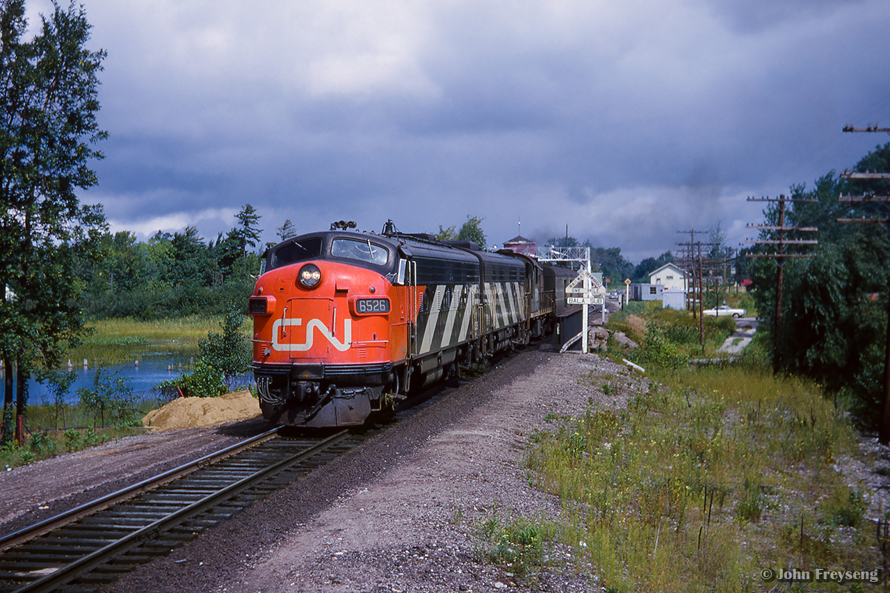 Departing Washago, train 52, the Super Continental, is southbound over the Severn River.  Note the drawbridge warning sign, old water tower.

Scan and editing by Jacob Patterson.