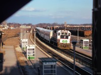 After <a href=https://www.railpictures.ca/?attachment_id=57103>rounding the curve</a> and making its station stop, GO 9806 shoves east towards the end of the line at Pickering.<br><br><i>Scan and editing by Jacob Patterson.</i>
