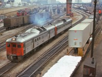 A westbound set of Budd cars accelerate through the busy Toronto Terminals Railway trackage west of Union Station.  An eastbound freight waits at a red signal beneath Spadina, while n SW1200RS works in the Bathurst North Yard, while at right, assorted passenger and yard power can be seen, including a Tempo RS18m, F units around the coaling plant, MLW S13s working the coach yard assignments, and a GM switcher at far right.

<br><br><i>Scan and editing by Jacob Patterson</i>.