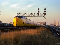 Turbo-equipped VIA 60 departs Toronto, entering the Kingston Sub at the end of Toronto Terminals Railway territory near the Don River.  Various pieces of freight rolling stock can be seen in Don Yard, while TTR's Cherry Street tower is in the distance at right.

<br><br><i>Scan and editing by Jacob Patterson.</i>
