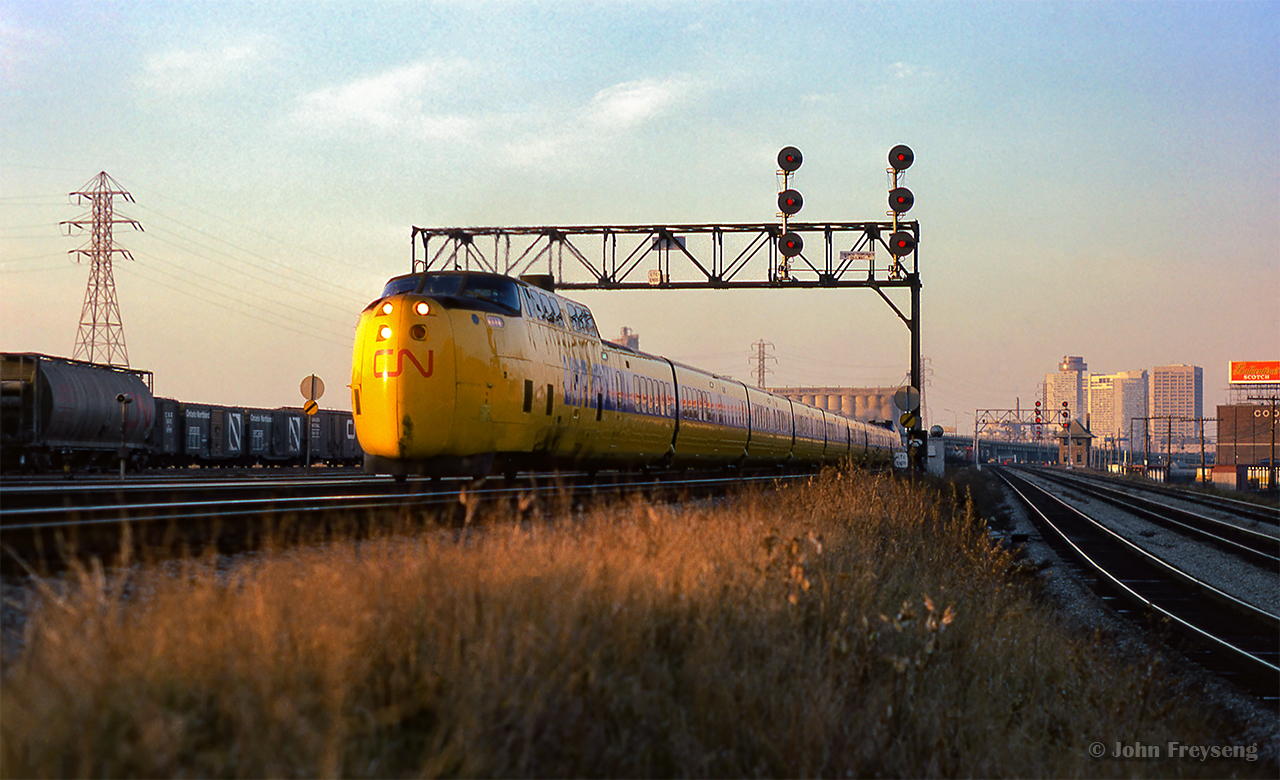Turbo-equipped VIA 60 departs Toronto, entering the Kingston Sub at the end of Toronto Terminals Railway territory near the Don River.  Various pieces of freight rolling stock can be seen in Don Yard, while TTR's Cherry Street tower is in the distance at right.

Scan and editing by Jacob Patterson.