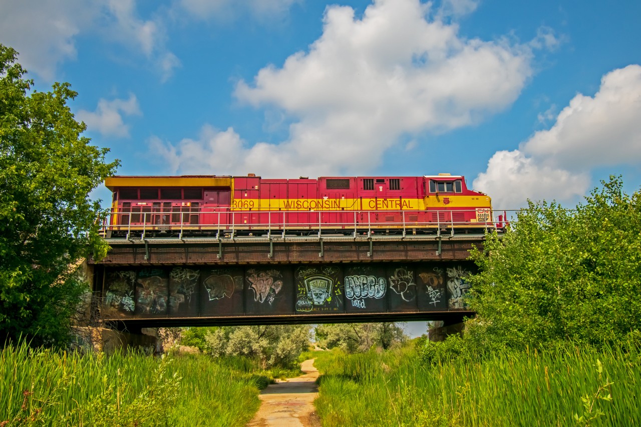 CN's Wisconsin Central heritage paint scheme rolling over a little bike path on the edge's of Winnipeg's St. Boniface and Elmwood neighborhoods. They are on their way into Symington Yard.