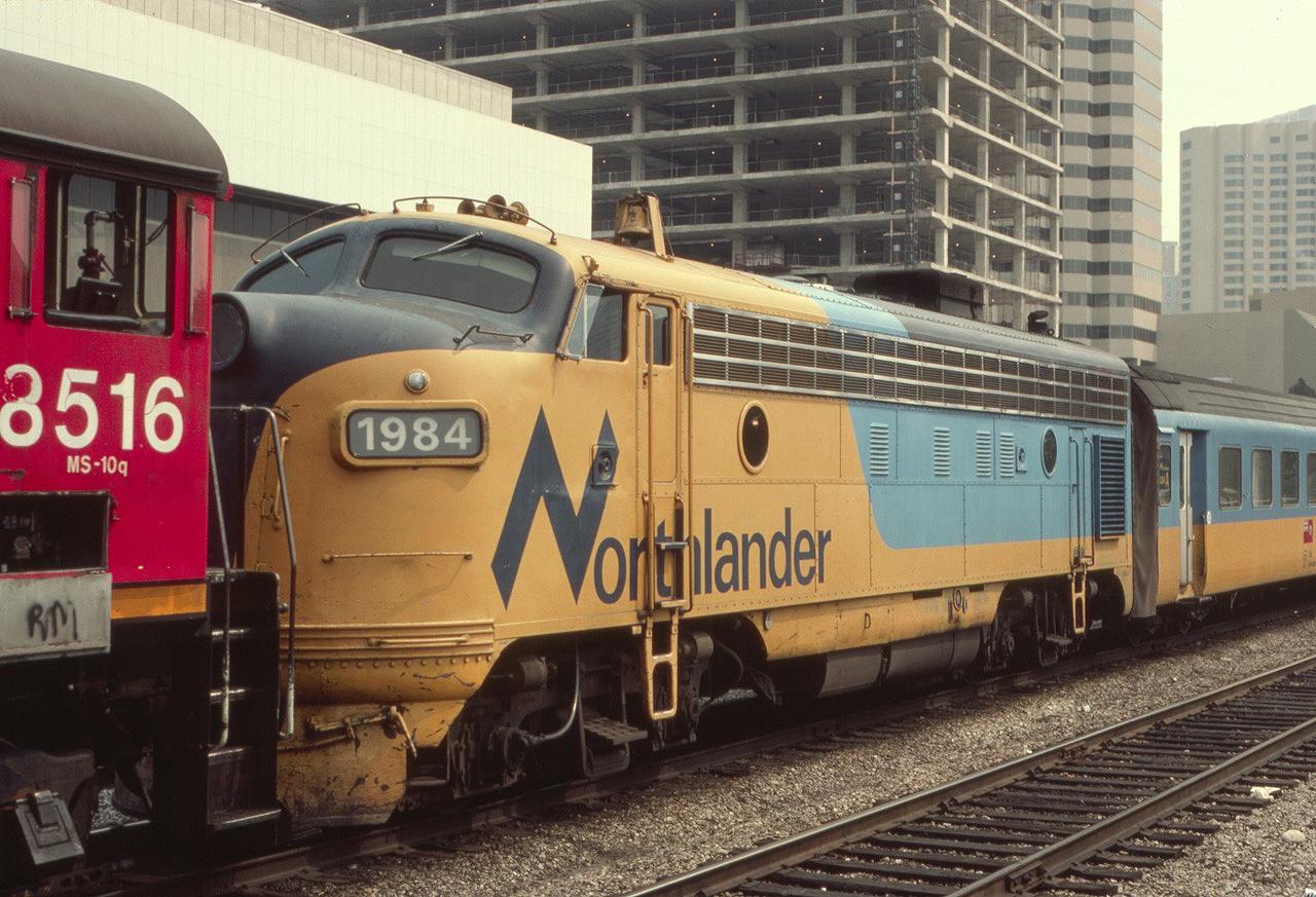 The Northlander passenger train with ONT 1984 on the head end is being brought down to the west end of Toronto Union Station from the coach yards by CN switcher 8516 on this hot summer day in August of 1985. Even way back then there was always a lot of construction activity in Toronto, as seen above the 1984.