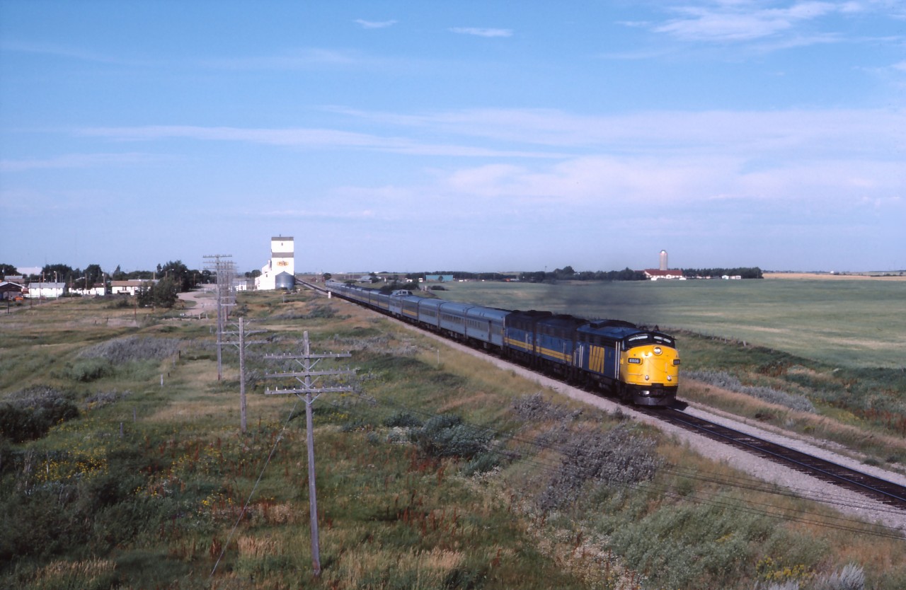 About 20 miles east of Regina lies the community of Balgonie, Saskatchewan. VIA No. 2, "the Canadian" breaks the stillness of a Sunday morning as it makes its east towards Broadview, Brandon and Winnipeg then eventually Thunder Bay, Sudbury, Toronto and Montreal. The 18 car train with three F units was a pretty typical summer consist at this time. Believe it or not, a second pair of passenger trains also plied these rails at the time; Nos. 109 and 110 between Winnipeg and Regina over CP rails then Regina-Saskatoon over CN lines. (Those trains replaced the full service Super Continental between Winnipeg and Saskatoon from November 15, 1981 until June 3, 1984 when the Winnipeg-Saskatoon-Edmonton-Prince Rupert "Panorama" was introduced, restoring service over CN between Saskatoon and Portage la Prairie.)