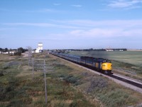 About 20 miles east of Regina lies the community of Balgonie, Saskatchewan. VIA No. 2, "the Canadian" breaks the stillness of a Sunday morning as it makes its east towards Broadview, Brandon and Winnipeg then eventually Thunder Bay, Sudbury, Toronto and Montreal. The 18 car train with three F units was a pretty typical summer consist at this time. Believe it or not, a second pair of passenger trains also plied these rails at the time; Nos. 109 and 110 between Winnipeg and Regina over CP rails then Regina-Saskatoon over CN lines. (Those trains replaced the full service Super Continental between Winnipeg and Saskatoon from November 15, 1981 until June 3, 1984 when the Winnipeg-Saskatoon-Edmonton-Prince Rupert "Panorama" was introduced, restoring service over CN between Saskatoon and Portage la Prairie.)