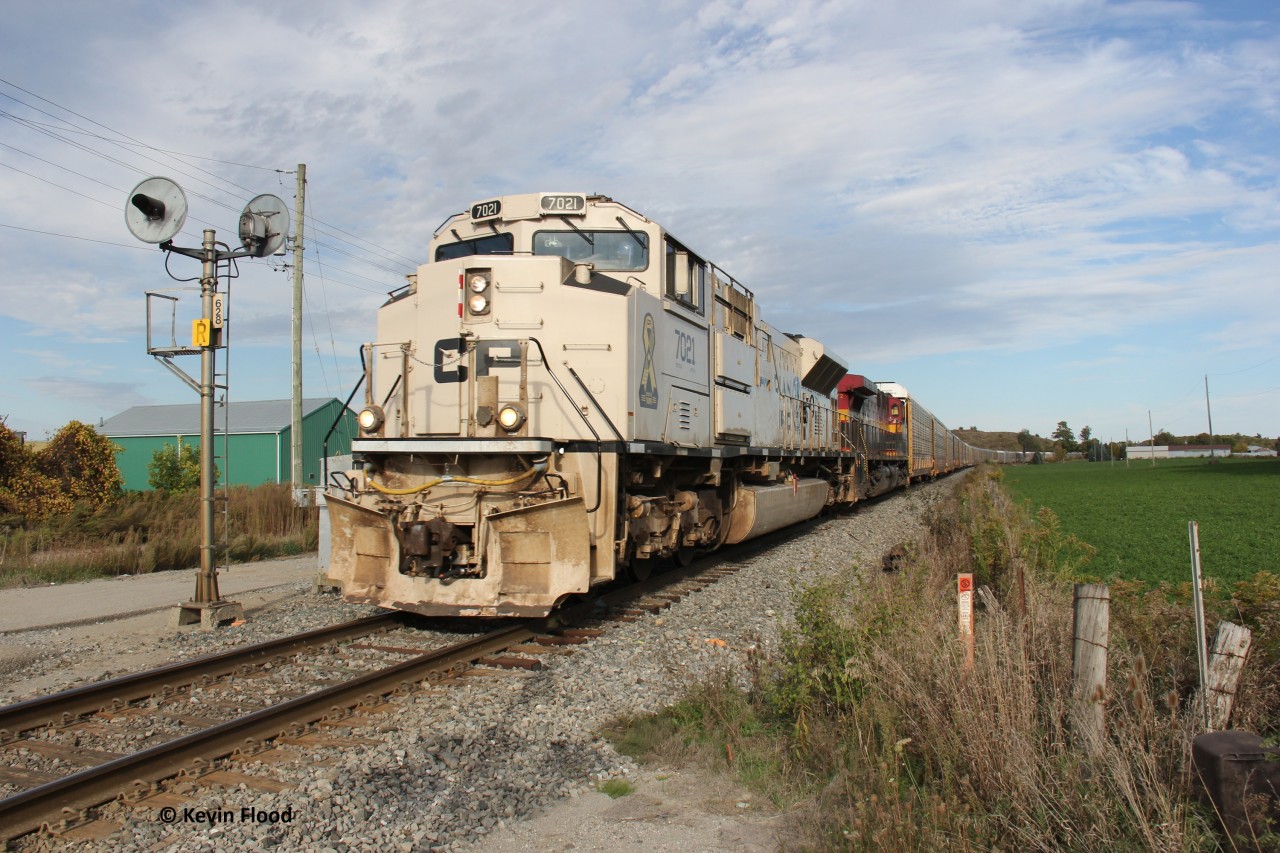 Military tribute unit CP 7021 and KCSM 4572 power CPKC 137 towards Wolverton for its usual work. It's pictured about to cross Dumfries Rd. between Cambridge and Ayr with an older style searchlight signal still online.
