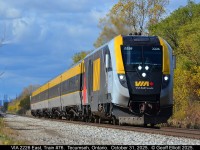 With the Detroit Renaissance Center looming in the background, VIA Charger #2229 leads eastbound VIA Train #76 out of Tecumseh, Ontario on October 31, 2025. With a mix of cloud and sun in the sky, and with about 1 minute to spare, the sun popped out to light up the shot and the little bit of Fall color that is still hanging around in the area.