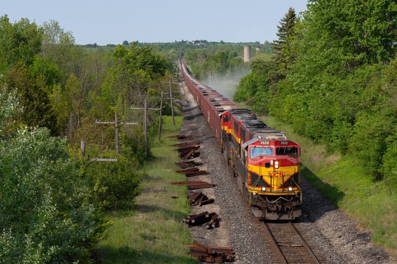 In this image, two KCS SD70MACe’s are on the head end of this Herzog GPS train, which is dumping ballast on the Galt Sub between Guelph Jct. and Orr’s Lake. After some confusion over the radio about work authorities and who had track time where, the WGA crew finally got the work authority they needed and the onboard Herzog crew began to work their magic in the area of expertise of ballast dumping and so the chase was on. I believe about ten to twelve foamers were on the Hwy 6 overpass waiting for this guy.