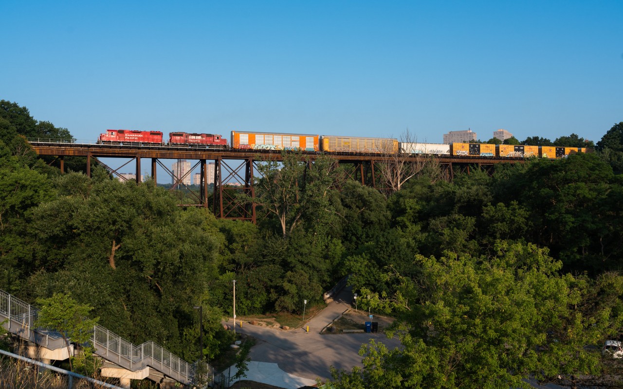 After waiting for the no.103's light power at Leaside, the Lambton transfer soars over top of Ernest Thompson Seton park on a beautiful summer evening. The hogger aboard 7307 has the throttle rapped to the wall for the climb uphill towards Toronto Yard in Scarborough.