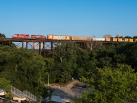 After waiting for the no.103's light power at Leaside, the Lambton transfer soars over top of Ernest Thompson Seton park on a beautiful summer evening. The hogger aboard 7307 has the throttle rapped to the wall for the climb uphill towards Toronto Yard in Scarborough.