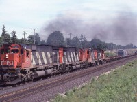 CN 2305 leads a westbound train with 111 cars out of Brantford, Ontario on July 11, 1981. The consist was: M636 2305, C630 2032, GP9 4585, and RS-18 3735. Lots of noise and exhaust! Those were the days!!!