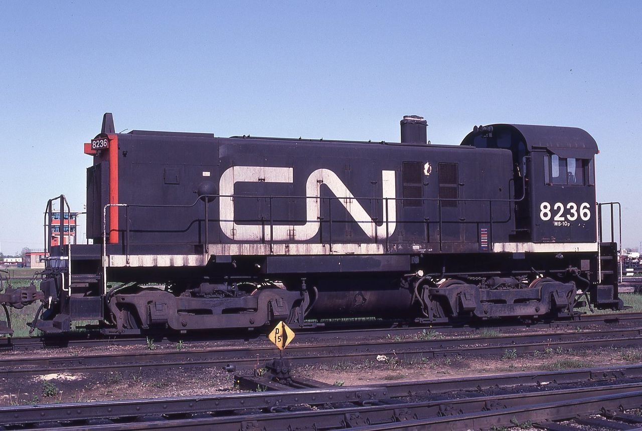With its stack neatly covered and bell removed, CN S12 8236, class MS-10p, waits the inevitable on a storage track at CN's Toronto Yard on a pleasant May afternoon in 1983. The unit was built by MLW in 1958 and officially retired on October 29, 1982, as being obsolete with only 646,000 miles accumulated.  The 25 year old unit still looked pretty good!!!!