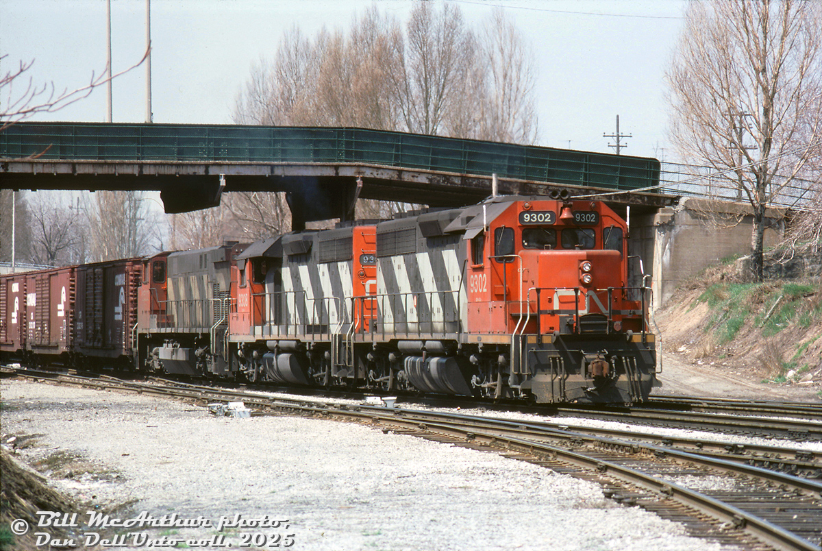 CN train #432 rolls eastbound through industrial Hamilton on the Grimsby Sub, lead by two of CN's small group of standard cab GP40's, 9302 and 9308, and M420 2552 trailing. The train is passing under the Mary Street overpass (alternate angle here), with the CN Hagersville Sub branching off the Grimsby Sub in the foreground.

Bill McArthur photo, Dan Dell'Unto collection slide.