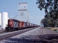 A grain peddler heads west through Oakville, Manitoba behind "lightweight" GP9s 4287 and 4317 with a train of mostly 40 foot grain boxes. For a more current view of this location, see Darcy Woodhall's photo https://www.railpictures.ca/?attachment_id=57562